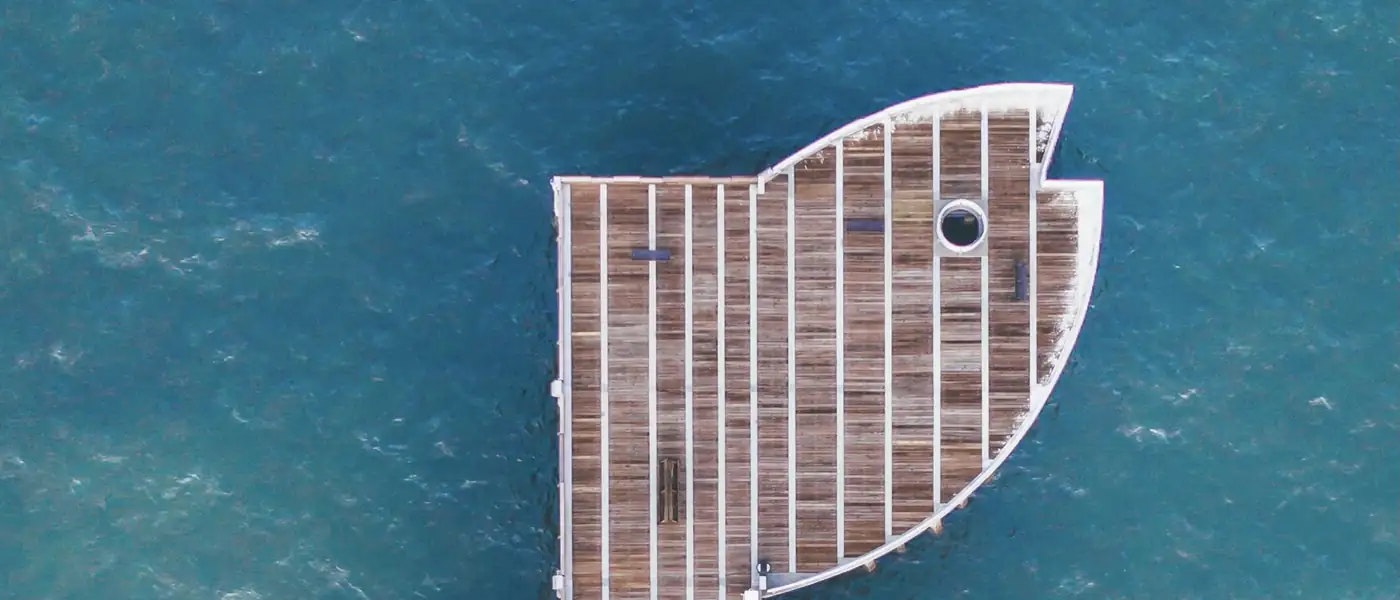 The Pompano Beach Fishing Pier seen from straight above, its fish-shaped end over blue-green Atlantic water.